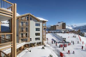 eine Gruppe von Menschen, die in einer Stadt Ski fahren in der Unterkunft Résidence Phoenix B by Leavetown Vacations in L'Alpe-d'Huez