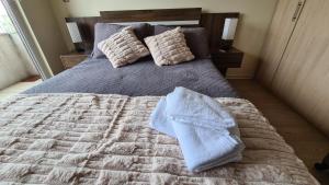a bed with a blanket and pillows on it at Departamento Estudio Central in Temuco