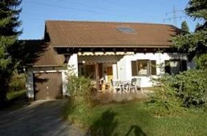 a white house with a brown roof and a yard at Ferienhaus Gamssteige im Feriendorf Reichenbach G11 in Nesselwang