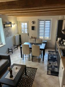 a living room with a table and a kitchen at Au Nid Douillet in Gilocourt +15 photos