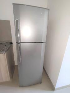 a white refrigerator in a kitchen next to a counter at Espacio Confortable y Agradable, Atlantis in Santa Cruz de la Sierra