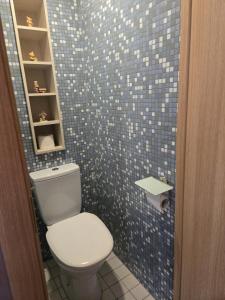 a bathroom with a toilet and a tiled wall at Kate Sea Apartment in Pärnu +17 photos