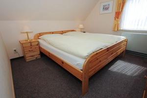 a bedroom with a wooden bed and a window at Ferienwohnungen Reinders Lammertshörn 22 in Bensersiel +39 photos