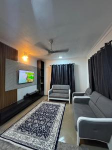 a living room with two couches and a flat screen tv at Cozy Stay Near Zanzibar Airport in Zanzibar City