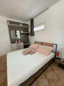 a bedroom with a large white bed with pink pillows at Villa Lidya Malpensa in Gallarate +8 photos
