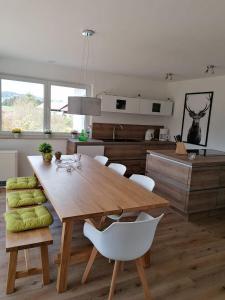 ネッセルヴァンクにあるFerienhaus Dachspfad im Feriendorf Reichenbach 3の木製のテーブルと椅子のあるキッチンとダイニングルーム +8枚の写真