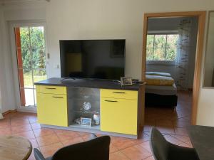 a living room with a tv and a yellow entertainment center at Rügen Fewo 211 in Parchtitz +5 photos