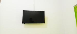 a flat screen tv hanging on a white wall at Penginapan Cendrawasih in Sorong