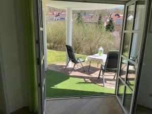 a sliding glass door leading to a patio with a table and chairs at Ferienwohnung Sonnengarten in Heiligenstadt