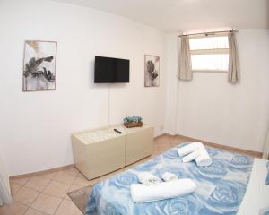 a bedroom with a bed with towels and a tv at Appartamento la casa di Lilli Anguillara Sabazia-Lago, Relax e Roma a portata di treno in Anguillara Sabazia