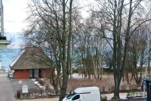 a white truck parked in front of a small red building at Villa Laura 12 in Kühlungsborn +10 photos