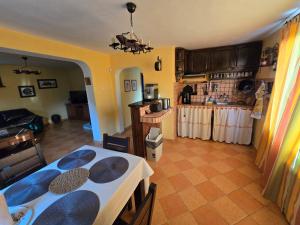 Una sala de estar con una mesa y una cocina. en Villa Skalolazka, en Belogradchik