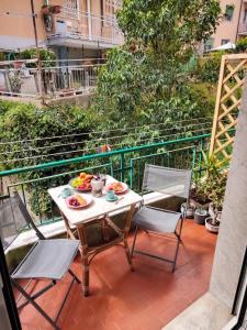 a table and chairs on a balcony with food on it at Genova Lux Apartment in Genova