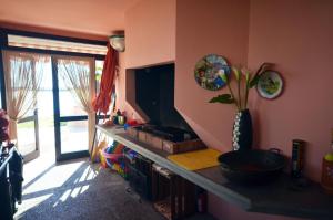 a living room with a tv and a shelf with a television at Tartaruga in Caleri