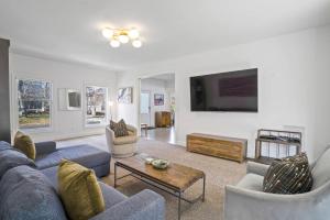 a living room with a blue couch and two chairs at East Hampton Retreat: Heated Pool, BBQ,Home Office in East Hampton +19 photos