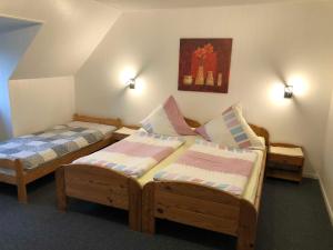 a bedroom with two beds and a picture on the wall at Ferienwohnungen Falkenhagen in Dörpstedt