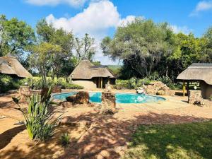 una piccola piscina in un cortile con una casa di Sambane Game Lodge a Bracondale