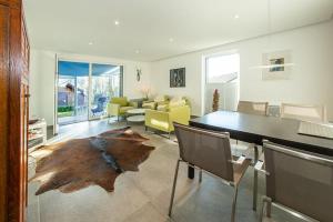 a living room with a table and chairs and a couch at Ferienhaus Gamssteige im Feriendorf Reichenbach G29 in Nesselwang +10 photos