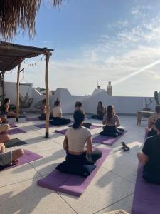 a group of people sitting in a yoga class at Wavy Days Surf Lodge in Tamraght Ouzdar