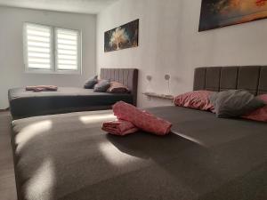 two beds in a room with red sheets on the floor at Apartmani Adi in Mostar