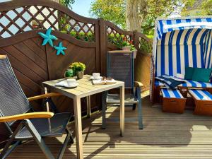 een houten terras met een tafel en stoelen erop bij Ferienwohnung Seestern in Sassnitz