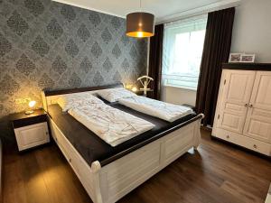 een groot bed in een slaapkamer met een raam bij Ferienwohnung Seestern in Sassnitz