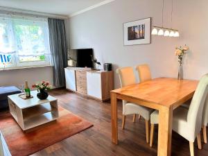 een woonkamer met een houten tafel en een eetkamer bij Ferienwohnung Seestern in Sassnitz
