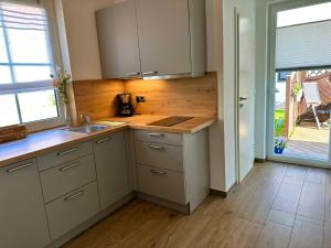 een keuken met witte kasten en een houten vloer bij Ferienwohnung Seestern in Sassnitz +2 foto's