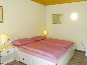 una camera da letto con un letto grande con lenzuola rosa di Kölp - Gentz H a Kölpinsee auf Usedom Altre 3 foto