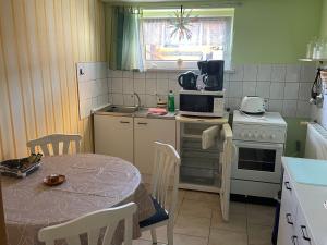 Una pequeña cocina con una mesa y un microondas. en Ferienwohnung Zum Anmselgarten, en Ribnitz-Damgarten 4 fotos más