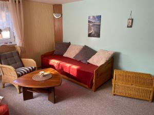 una sala de estar con un sofá y una mesa en Ferienwohnung Zum Anmselgarten, en Ribnitz-Damgarten
