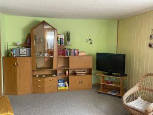 sala de estar con centro de entretenimiento y TV en Ferienwohnung Zum Anmselgarten, en Ribnitz-Damgarten