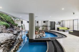 an indoor pool with a waterfall in a building at Aparta Hotel Roca Marina in Santa Marta