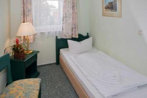 ein Schlafzimmer mit einem Bett und einer Lampe und einem Fenster in der Unterkunft Fewo Rosenhof 02 in Kühlungsborn + 4 Fotos