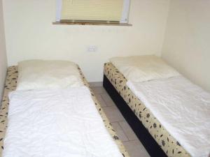Dos camas una al lado de la otra en una habitación. en Bungalow Quooß GM 69657, en Graal