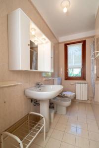 une salle de bain avec un lavabo et des toilettes dans l'établissement Leccio, à Albarella