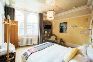 a bedroom with a large bed and a window at The Culpeper Bedrooms in London