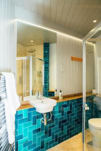 a bathroom with a sink and a shower and a toilet at The Culpeper Bedrooms in London