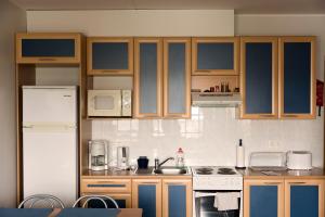 a kitchen with wooden cabinets and a white refrigerator at Pärnu Karusselli Beach Apartment in Pärnu