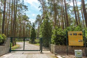 LütowUrlaub im Bungalow mitten im Wald的森林前有标志的大门