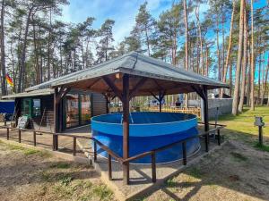 LütowUrlaub im Bungalow mitten im Wald的小屋前方的凉亭,配有蓝色浴缸