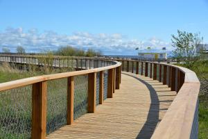 a wooden boardwalk leading to the beach at Pärnu Karusselli Beach Apartment in Pärnu +8 photos