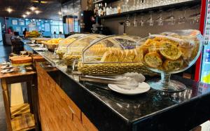 a buffet line with many different types of bread and sandwiches at Riellis Center Hotel in Botucatu