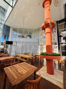 a restaurant with wooden tables and chairs and a pole at Riellis Center Hotel in Botucatu +43 photos