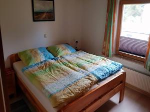 ルブミンにあるFerienhaus Seeadler DH-39518のベッドルームにカラフルな掛け布団付きのベッド1台 +7枚の写真