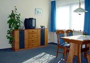 a living room with a television and a table and chairs at Haus Dornröschen in Koserow
