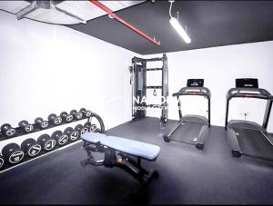 um ginásio com duas passadeiras e pesos em 2 Br Luxury duplex Canal View, 5 min to AUH Airport, Yas island , Raha Mall em Abu Dhabi