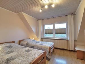 two beds in a room with a window at Familie Ischmund - Gemütliche Ferienwohnung im hohen Norden in Oeversee
