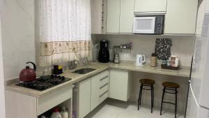 a kitchen with a sink and a stove top oven at Casa Piscina Guaratuba 400mt praia in Guaratuba