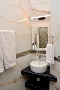 a bathroom with a sink and a mirror and towels at Casa Angel in Morelia